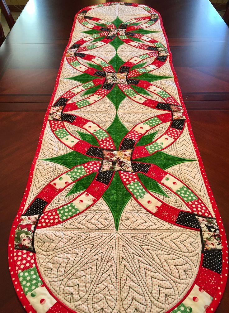 a long table runner with green, red and white designs