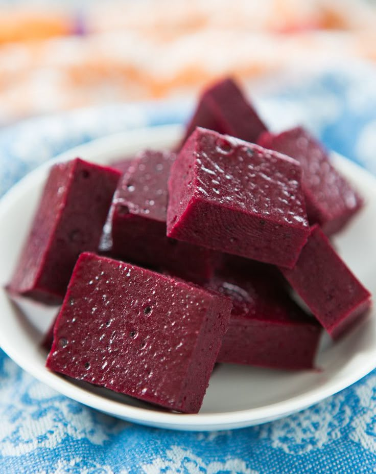 beet cubes on a white plate sitting on a blue and white tablecloth