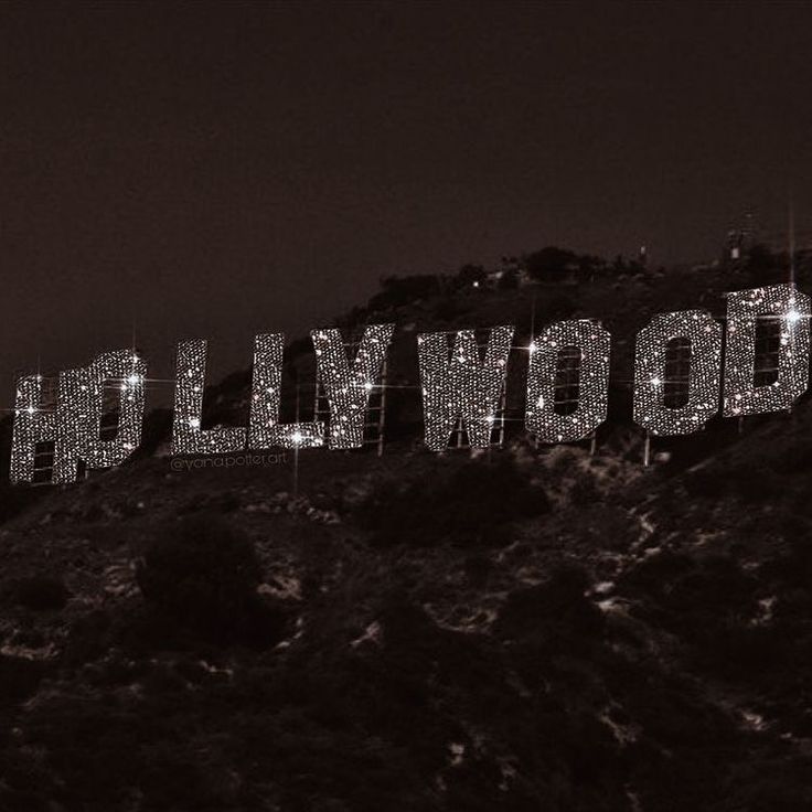 the hollywood sign lit up at night on top of a hill in black and white