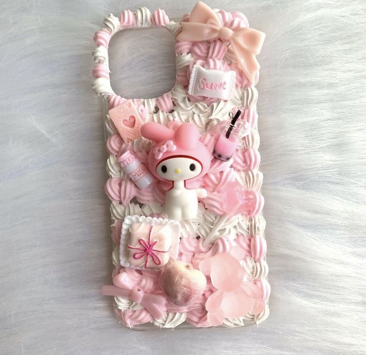 a cell phone case with an image of a hello kitty doll and accessories on it