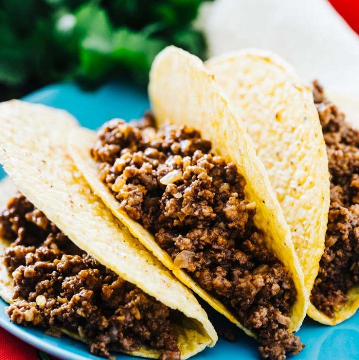 three tacos on a blue plate with the words authentic mexican rice next to it