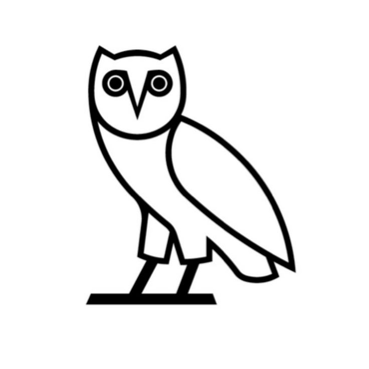 an owl sitting on top of a wooden table next to a white sign with the words,