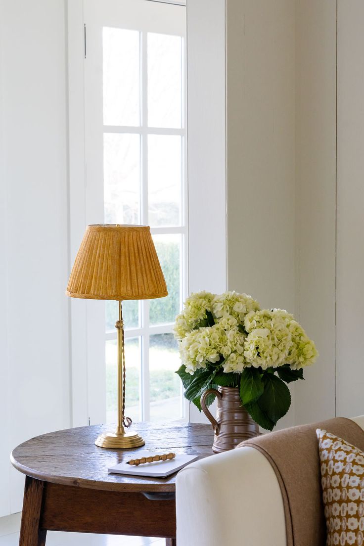 a table with a lamp and flowers on it