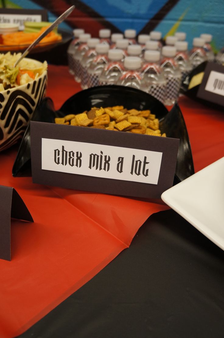 a table topped with plates and bowls filled with food next to water bottles on top of a red table cloth