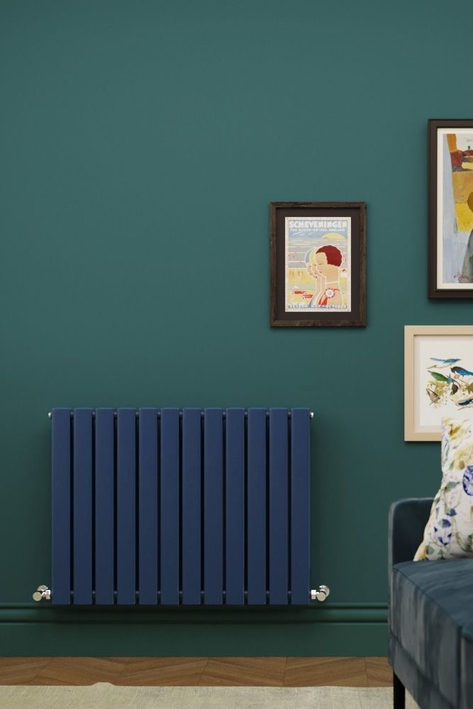 a blue radiator in a living room next to pictures on the green wall