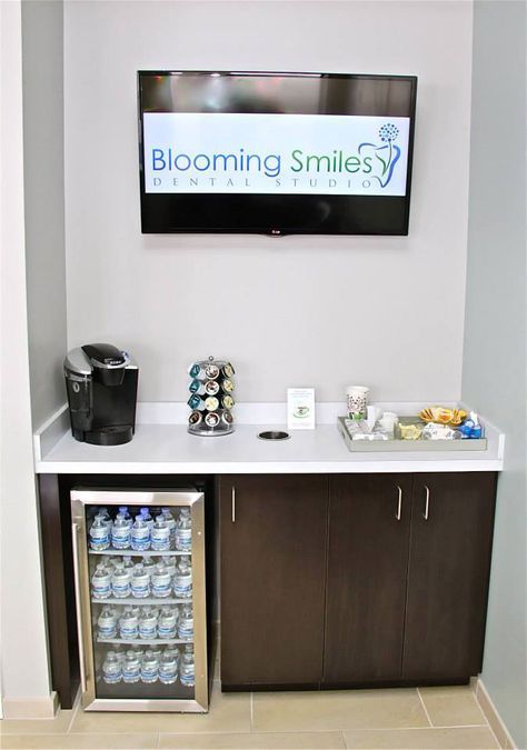 there is a small refrigerator with drinks and snacks in front of the tv on the wall