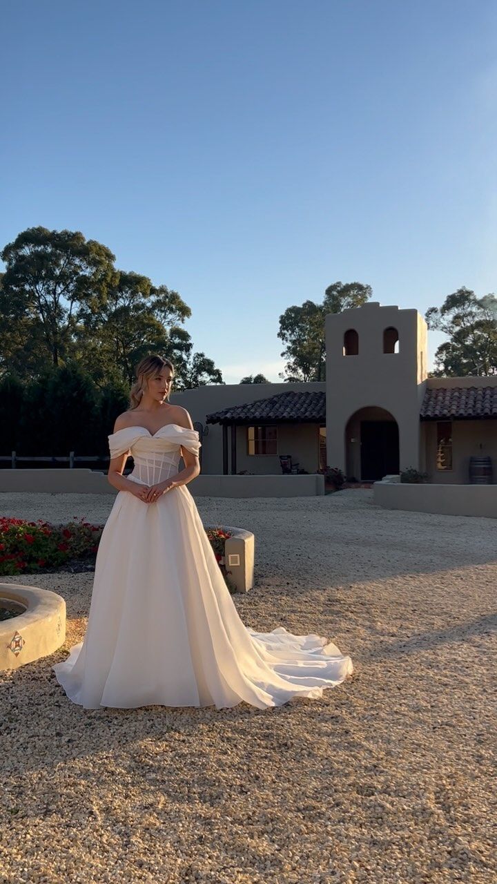 a woman in a wedding dress standing outside