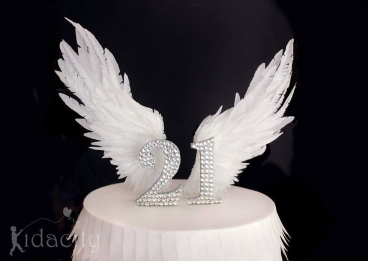 a white cake topped with an angel wings number twenty two tiered cake topper