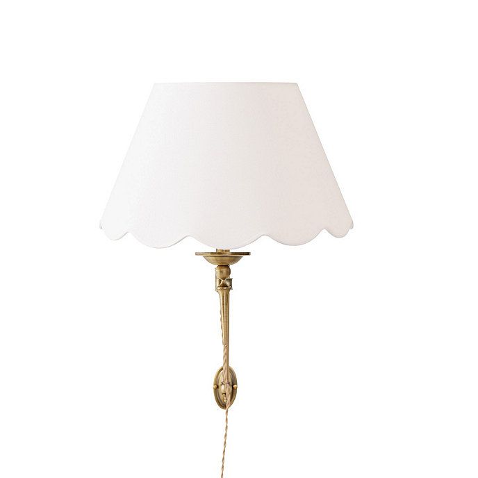 a lamp that has a white shade on it and is attached to a wall or ceiling