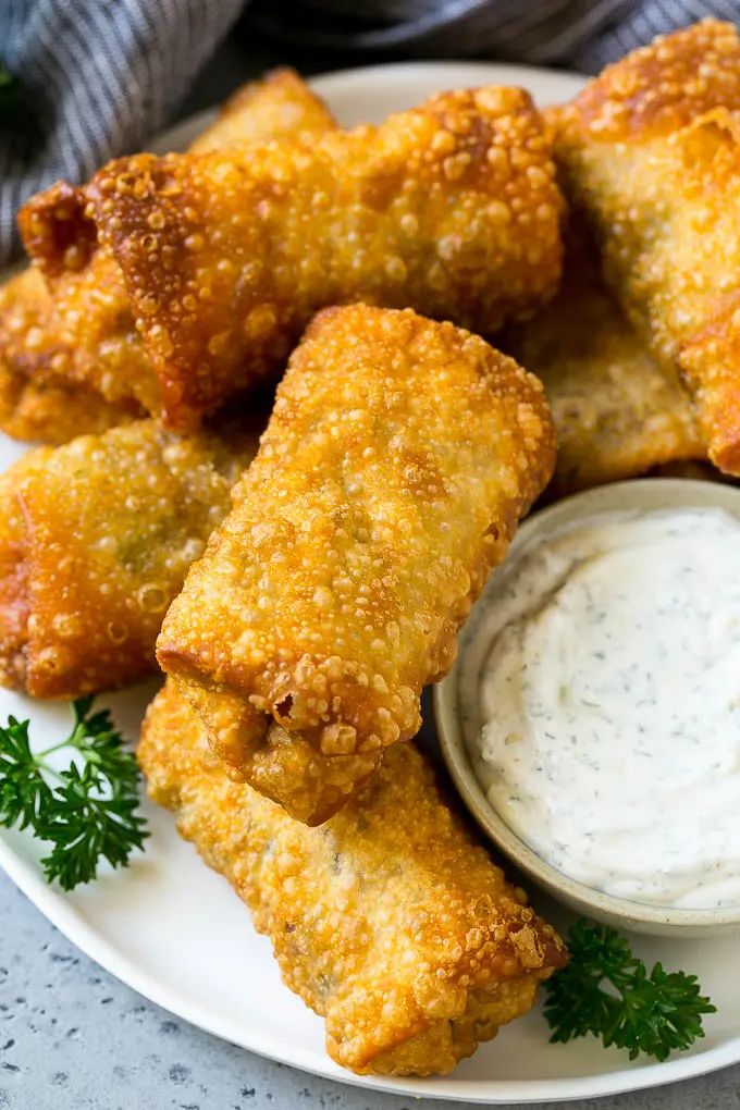 some fried food on a white plate with ranch dressing