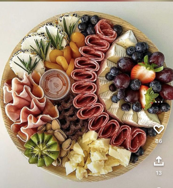 a platter filled with fruit, crackers and cheeses