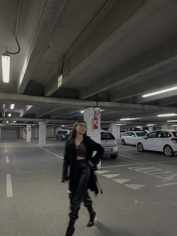 a woman standing in an empty parking garage