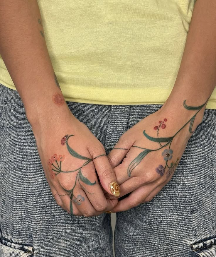 a person with tattoos on their hands holding something in the other side of her body