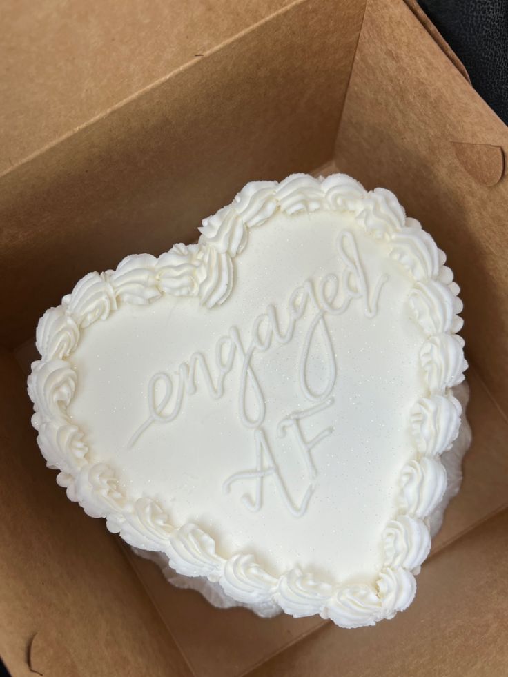 a white heart shaped cake in a box