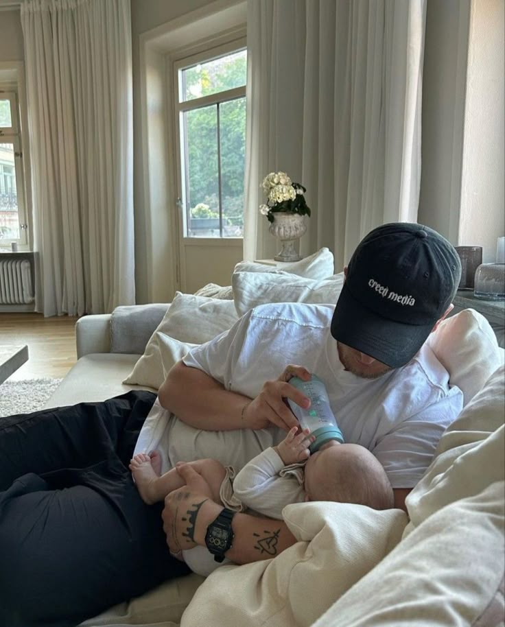 a man laying on top of a bed holding a baby