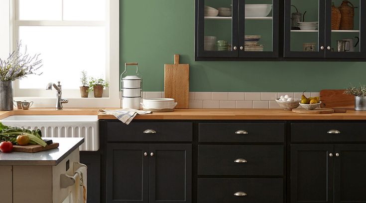 a kitchen with purple walls and black cabinets