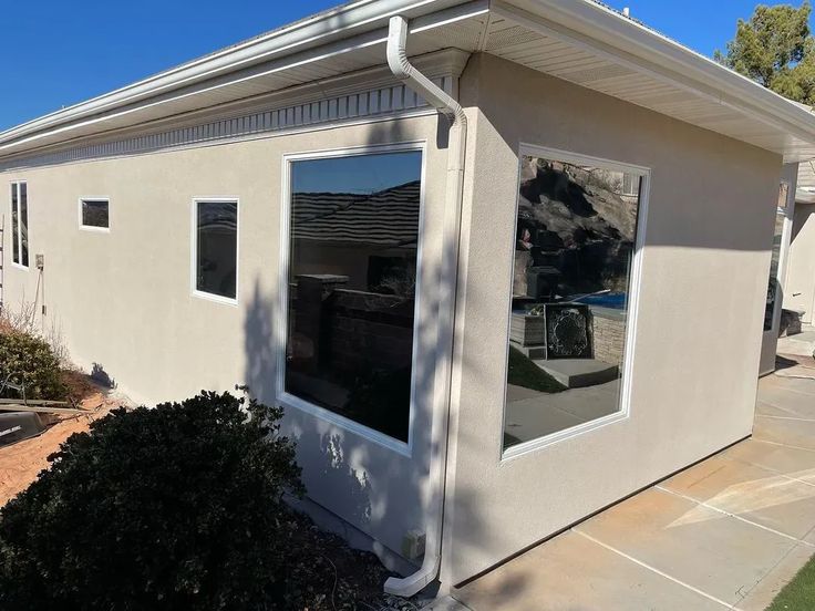 a small house with a car parked in the front yard and windows on each side