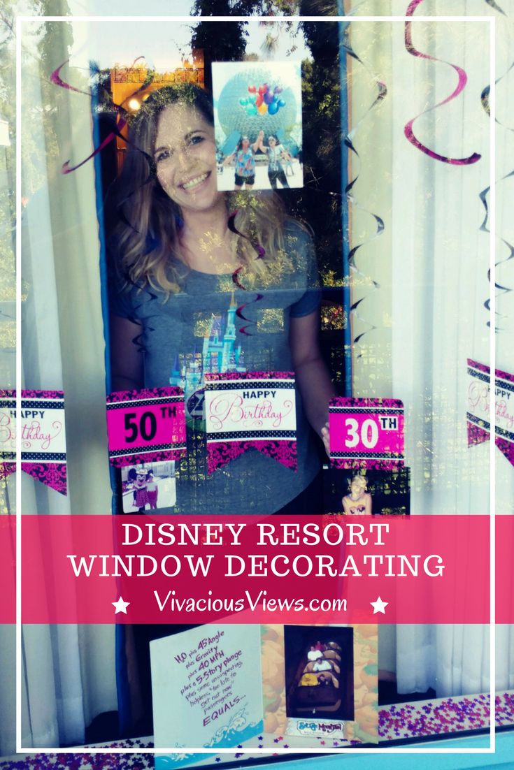 a woman standing in front of a window decorated with disney resort decorations and streamers