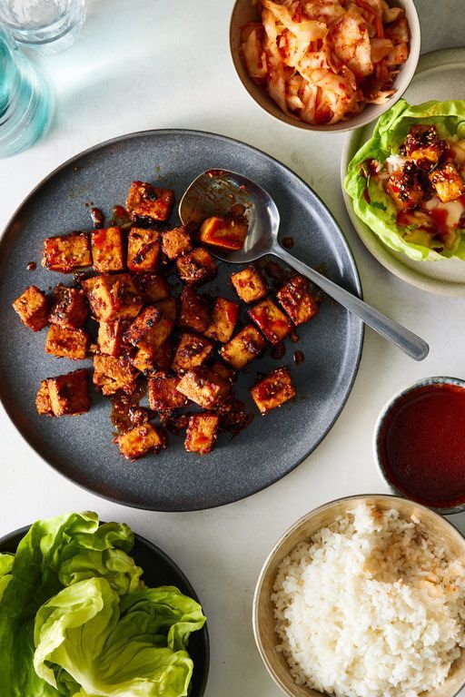 a plate with tofu, rice and lettuce on it next to other dishes