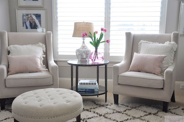 a living room with two chairs and a table in front of a window that has flowers on it