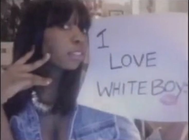 a woman holding up a sign that says i love white boy