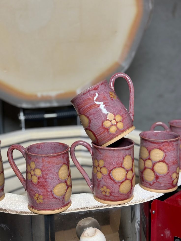 coffee cups with paw prints on them sitting on a stand in front of an oven