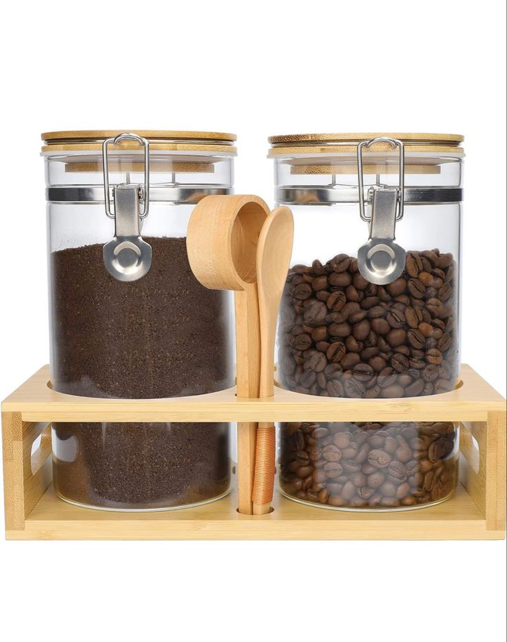 two glass jars filled with coffee beans and cinnamons on top of a wooden shelf