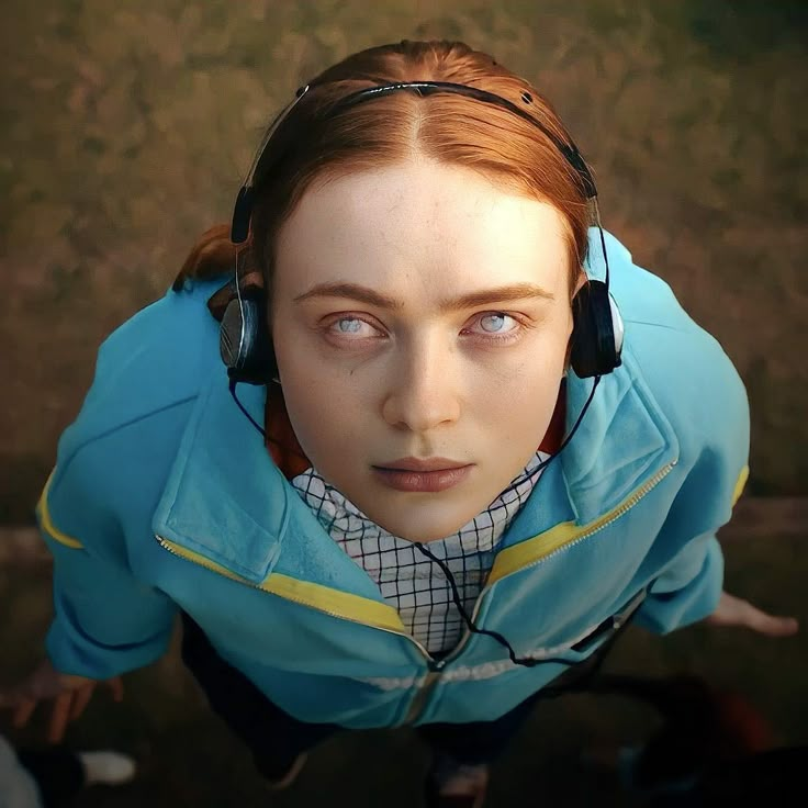 a woman with headphones on looking up at the camera