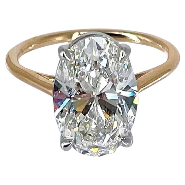 an oval cut diamond ring in yellow gold