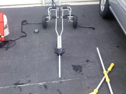 a car is parked in the parking lot next to a pole with two skis on it