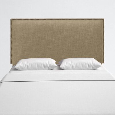 an upholstered headboard on a bed with white linens and pillows,