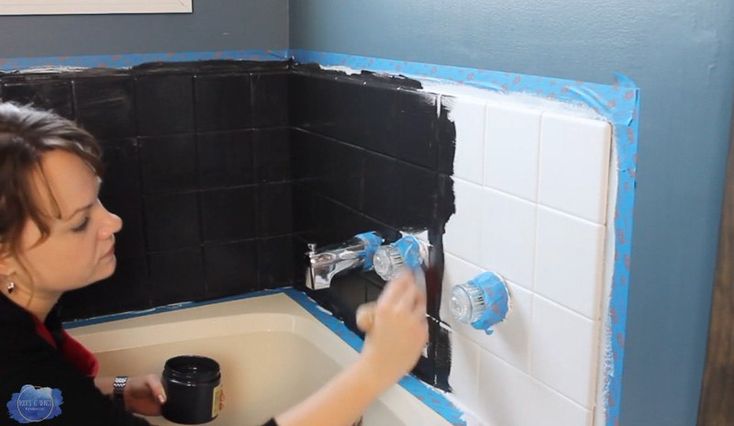 a woman is painting the walls of a bathroom with blue and white paint on it