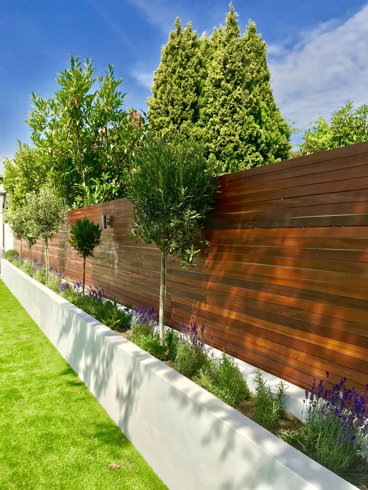 a fenced in backyard with grass and trees