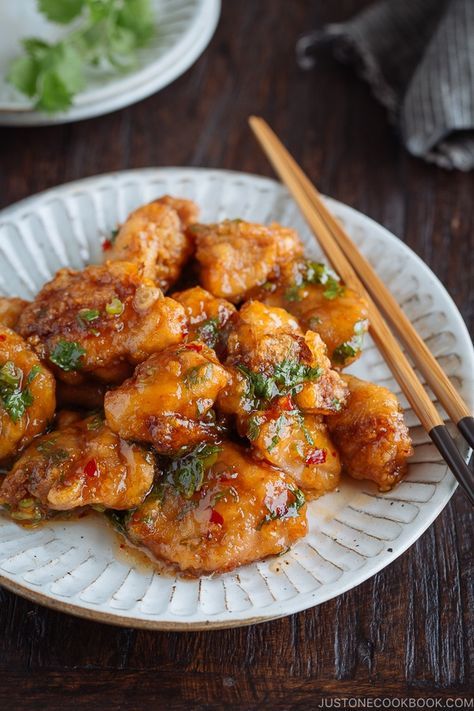 a white plate topped with chicken and chopsticks