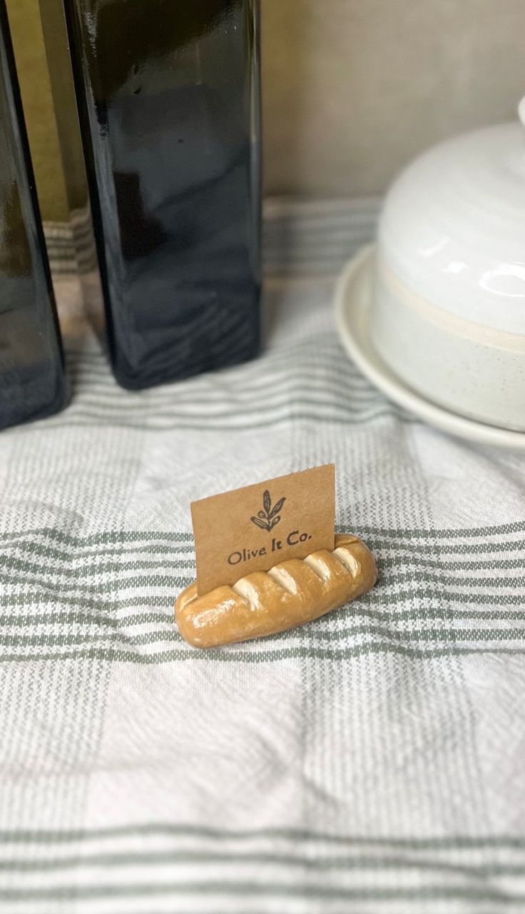 a hot dog bun sitting on top of a table next to two black vases