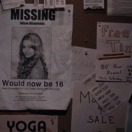 a bulletin board covered in papers with missing posters on it's sides and words written all over the walls