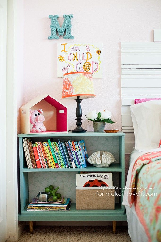 a child's bedroom with bookshelf and toys on the shelf next to the bed