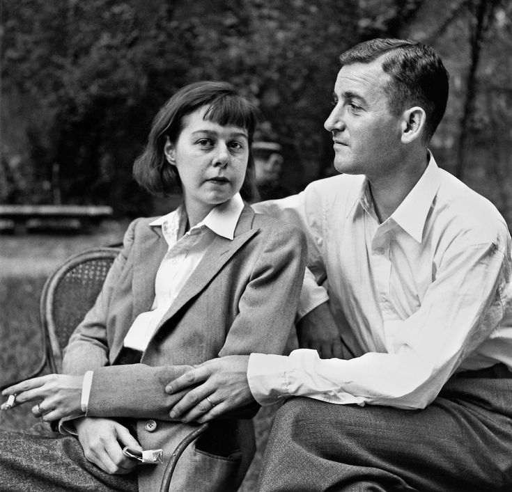 an old black and white photo of a man and woman sitting next to each other