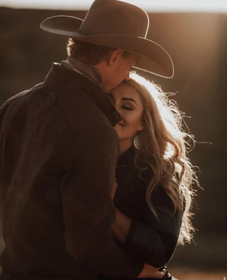 a man in a cowboy hat kissing a woman