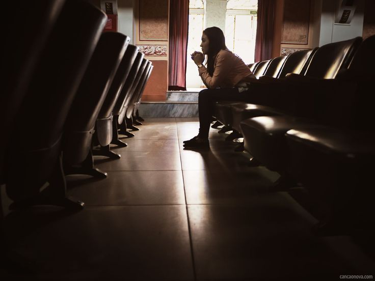 a woman sitting on a bench in front of a window