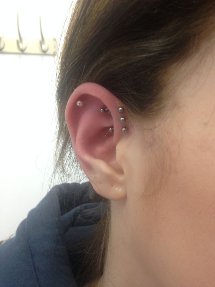 a close up of a person's ear with piercings