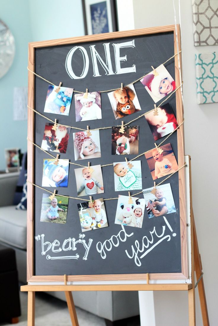 a blackboard with pictures hanging on it and the words one year written in chalk