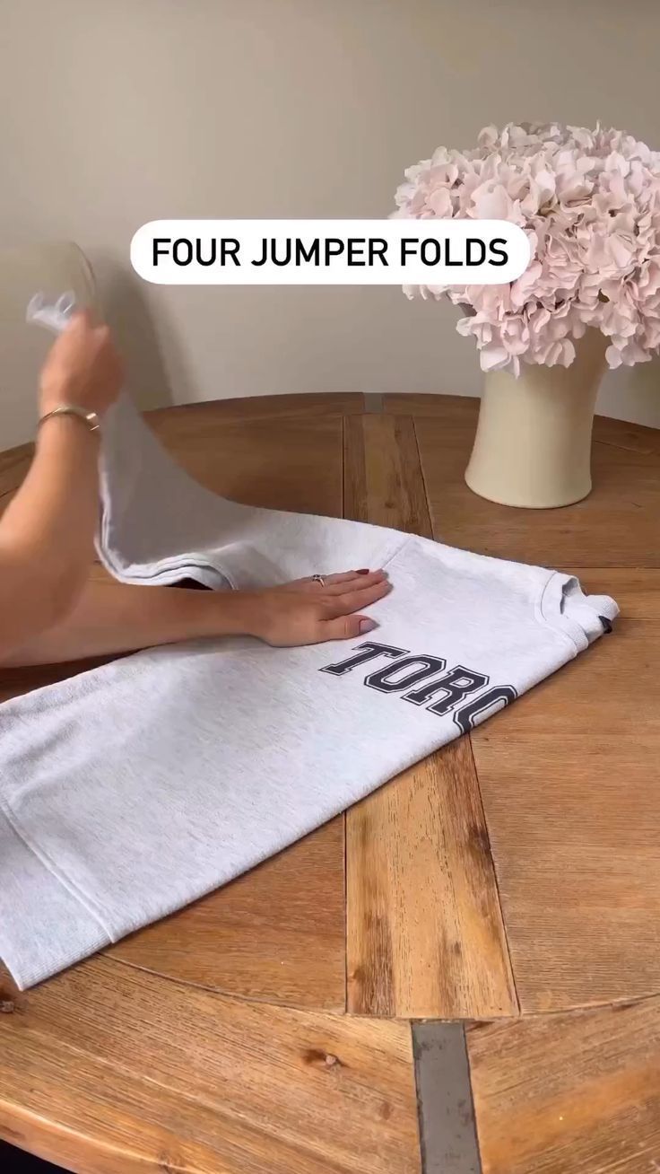 a person sitting at a table with their feet on a towel and the words four jumper folds