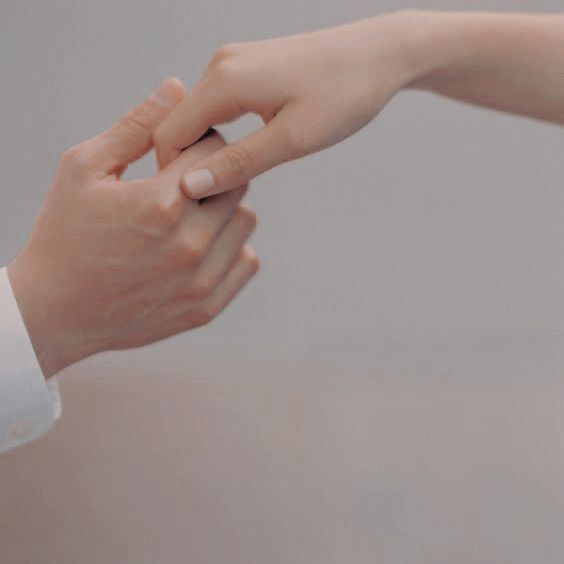 two people holding hands and touching each other