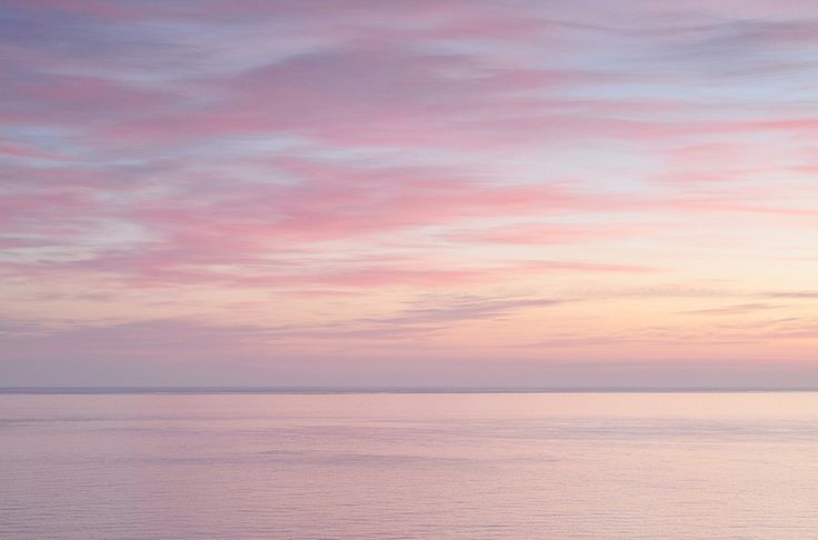 the sky is pink and purple as it reflects in the water