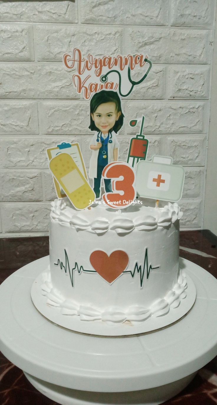 a white cake sitting on top of a table next to a brick wall with a stethoscope