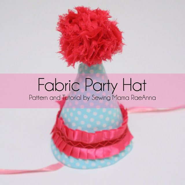 a pink and blue polka dot party hat with red pom - poms on top