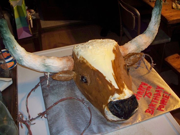 a cake shaped like a cow's head on top of a table in a room