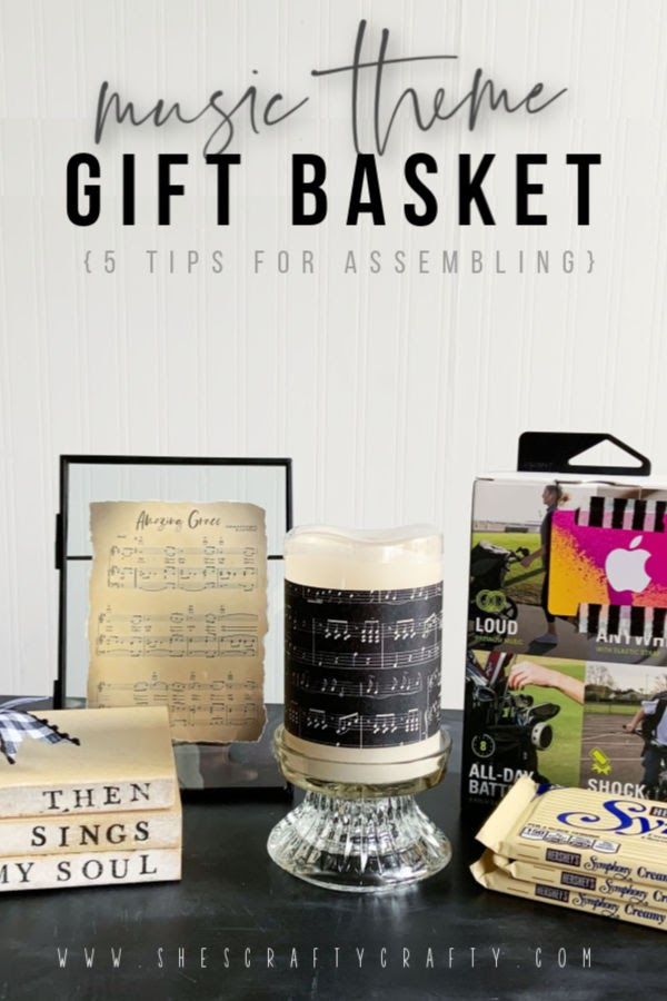 a table topped with books and candles next to a sign that says music theme gift basket