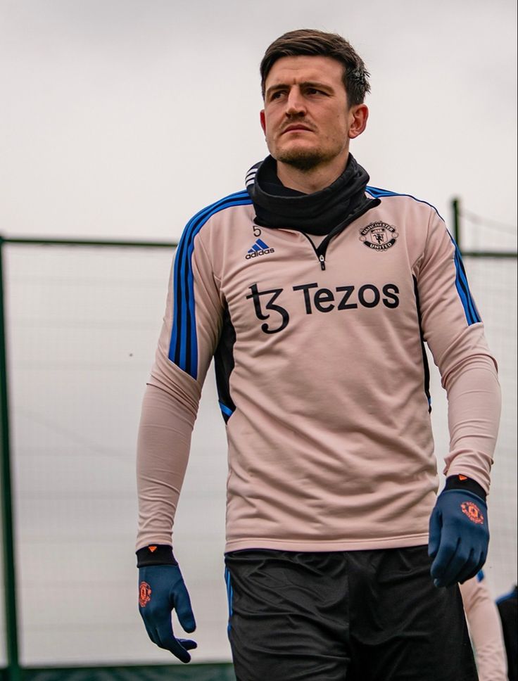 a soccer player wearing blue gloves standing on the field